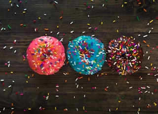 three donuts with sprinkle toppings