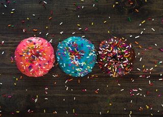 three donuts with sprinkle toppings