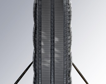 A modern high-rise building with a sleek, metallic facade and vertical structures. The symmetrical design is enhanced by the presence of two large, diagonal support beams extending from the sides. The building's surface features a series of reflective, grid-like patterns creating a futuristic and industrial aesthetic against a clear, pale sky.