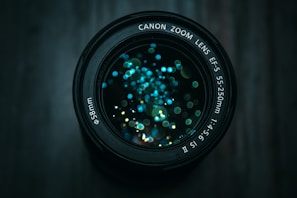 Close-up of a vintage camera lens with reflections of city lights in the glass.