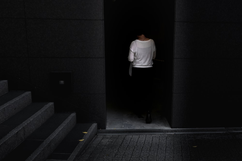 woman walking near gray stair inside building