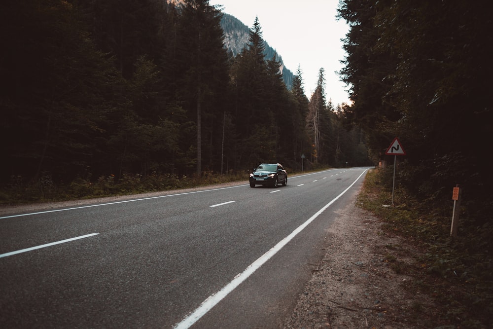 time lapse photography of car passing through trees