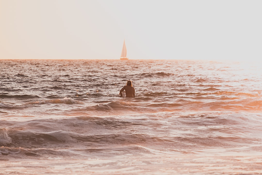person riding surfboard during golden hour