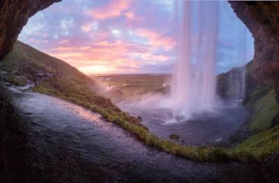 A vibrant sunset over the Brazilian side of Iguazu Falls with tourists enjoying the view.