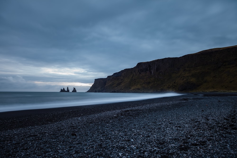 grey cliff near body of water