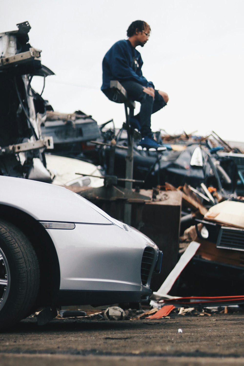 man in blue jacket sitting on gray metal stand