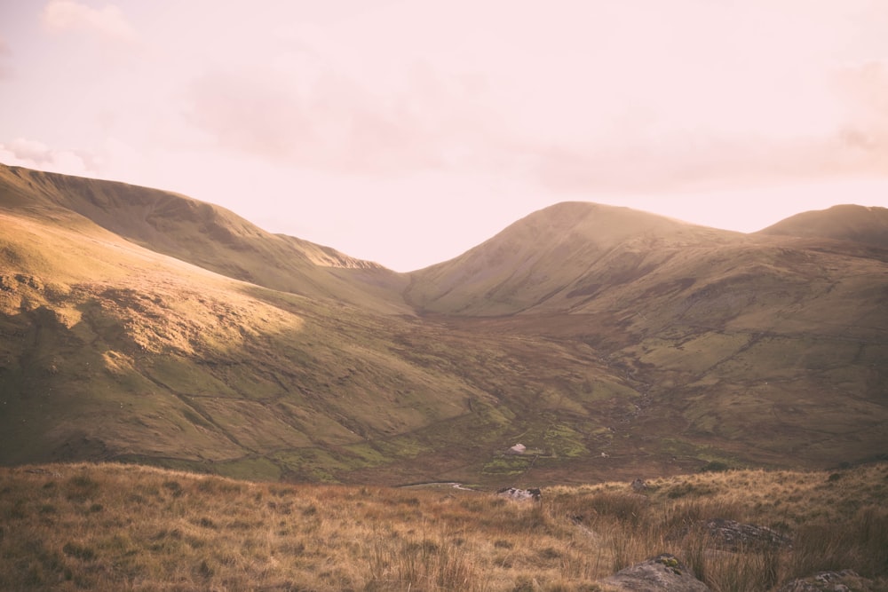 brown and green hills under cloudy sky