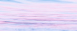 Soft pastel waves blending into a misty horizon with gentle light reflections