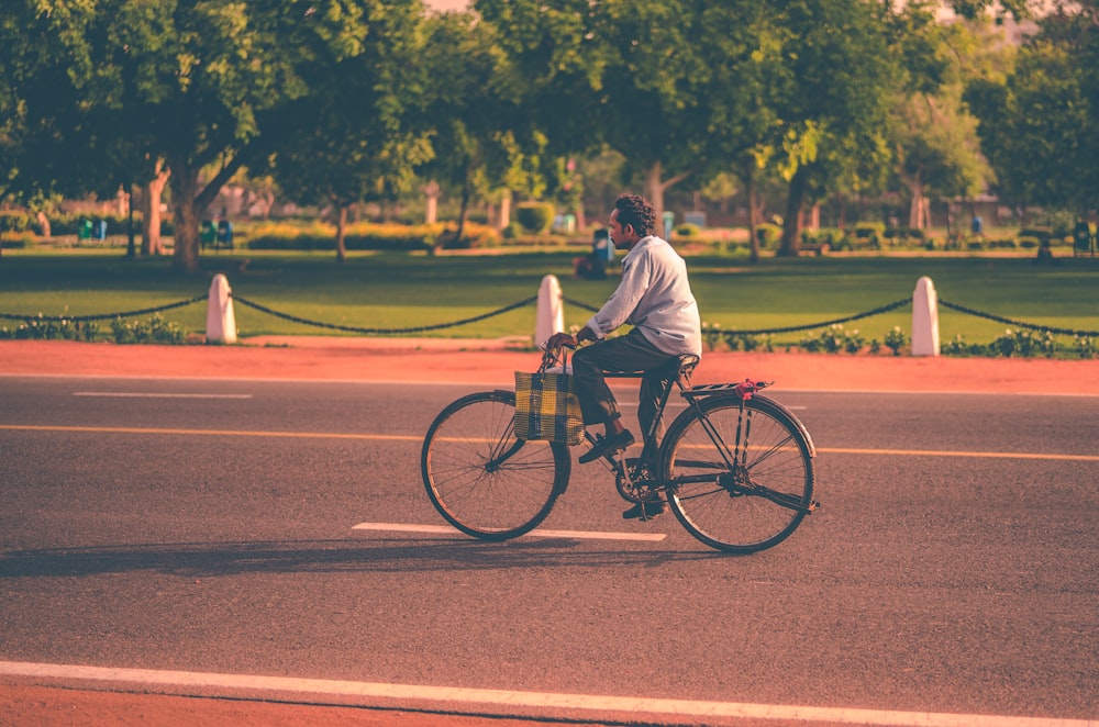 man riding bike on concrete pavement