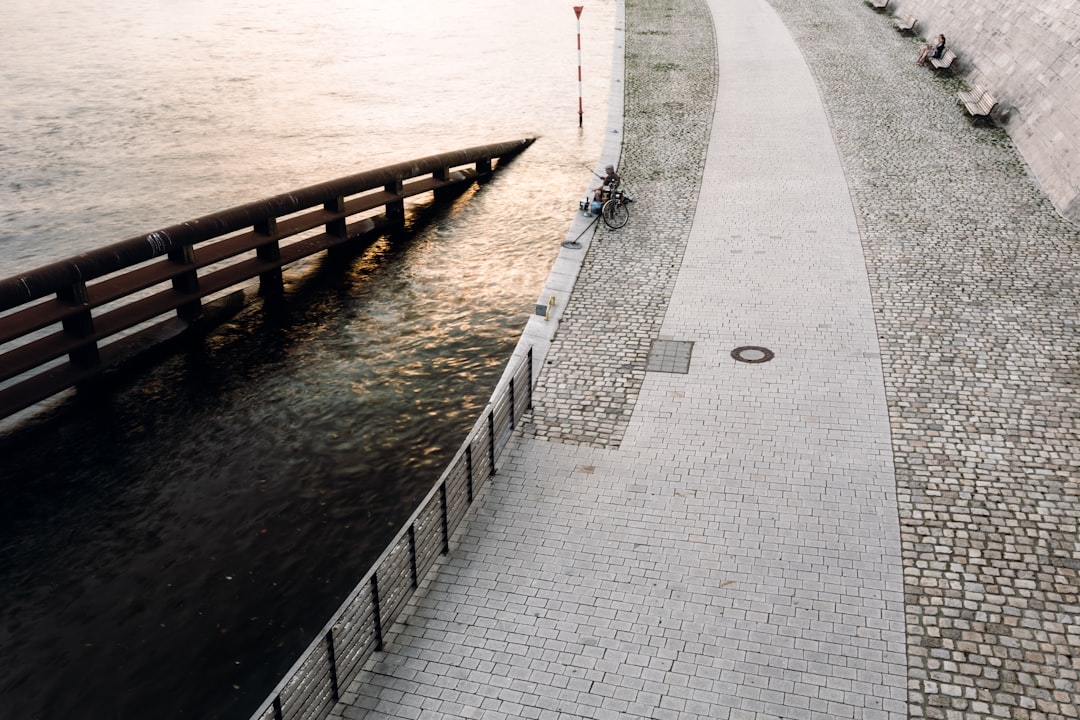 high angle photo of man fishing near the bridge