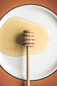 honey dipper on round plate with honey