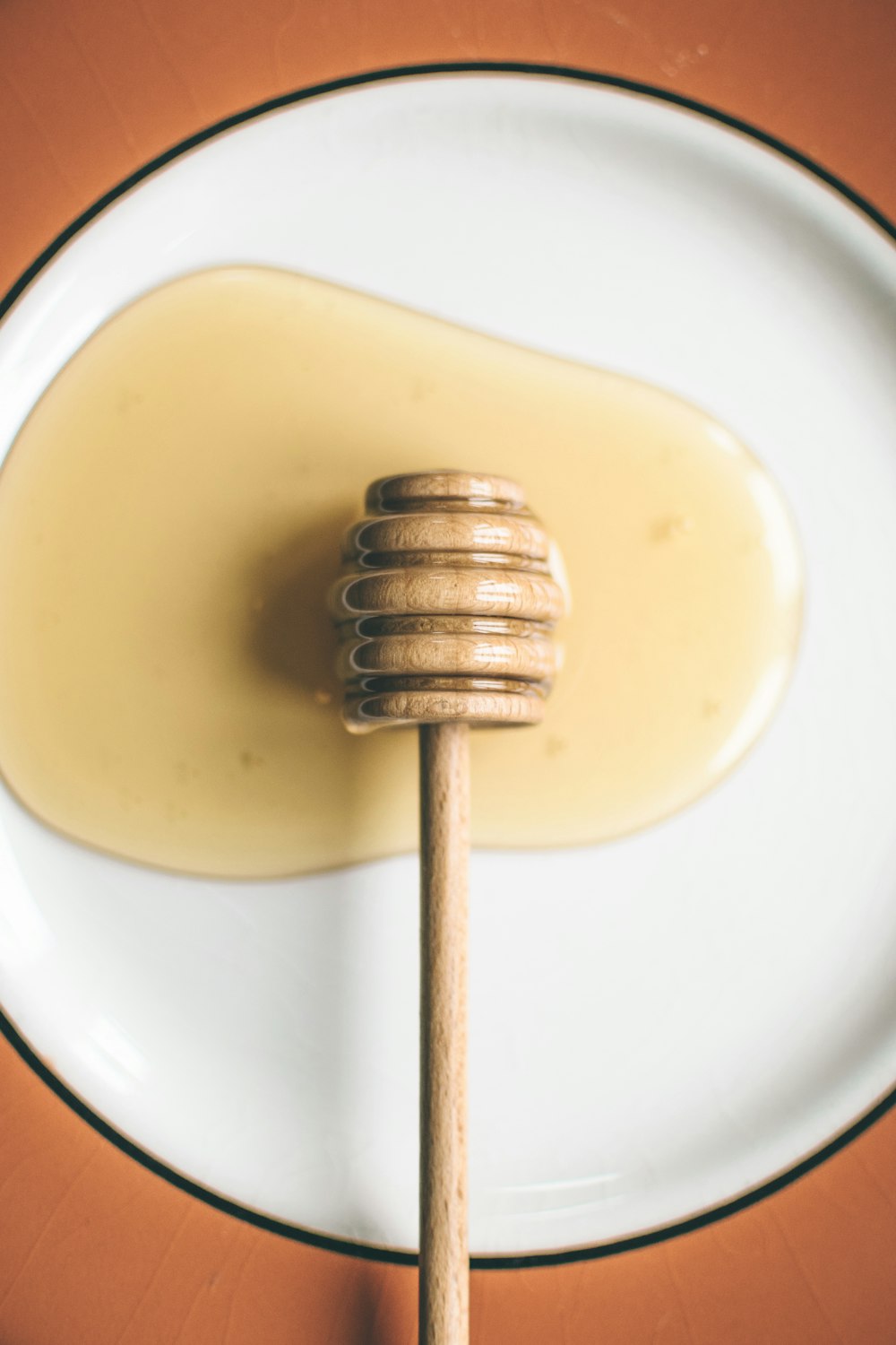 honey dipper on round plate with honey
