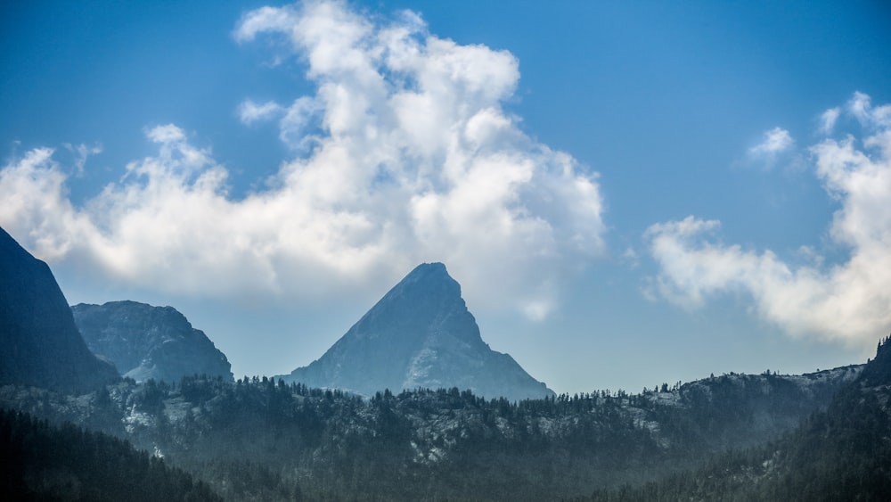landscape photography of mountains under white clouds
