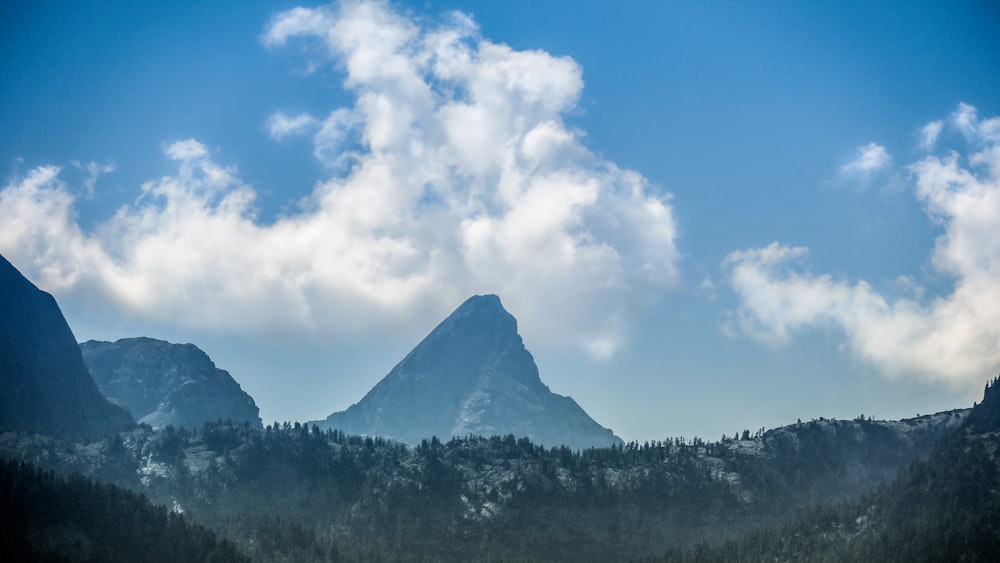 白い雲の下の山々の風景写真