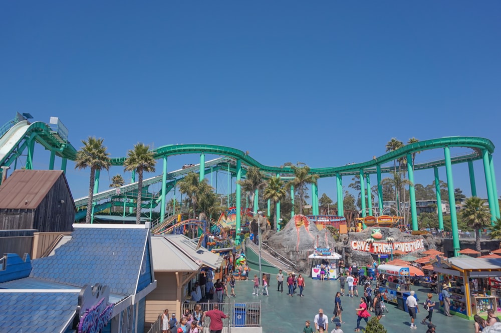 group of people near teal roller coaster