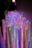 An array of upright, colorful LED light sticks, each glowing with vibrant hues of red, green, blue, purple, and pink, creating a mesmerizing visual effect in a dimly lit setting.