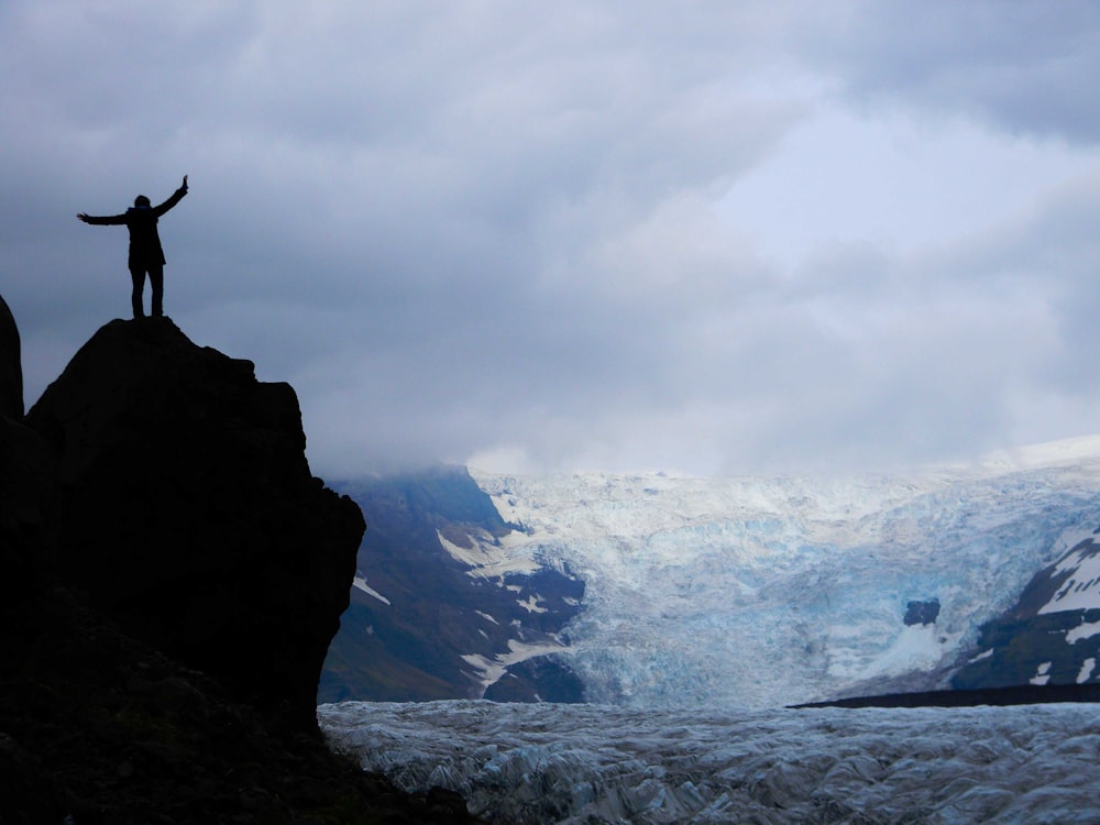 silhouette of a person on top of rock