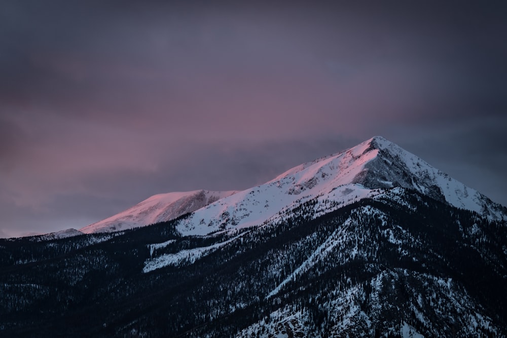 snow capped mountain during black cloudy day