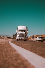 white freight truck on grey concrete road