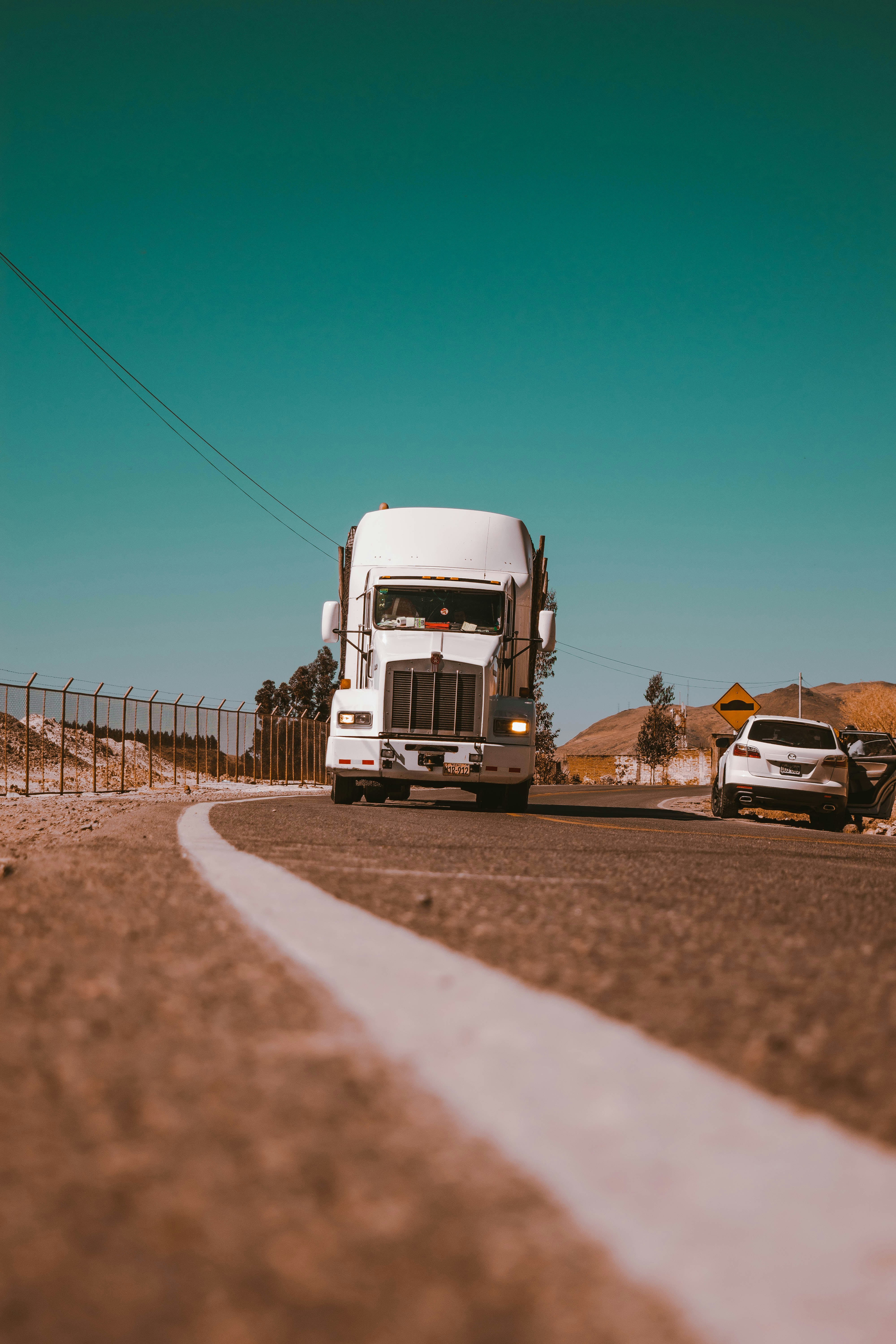 white freight truck on grey concrete road