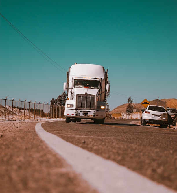 white freight truck on grey concrete road