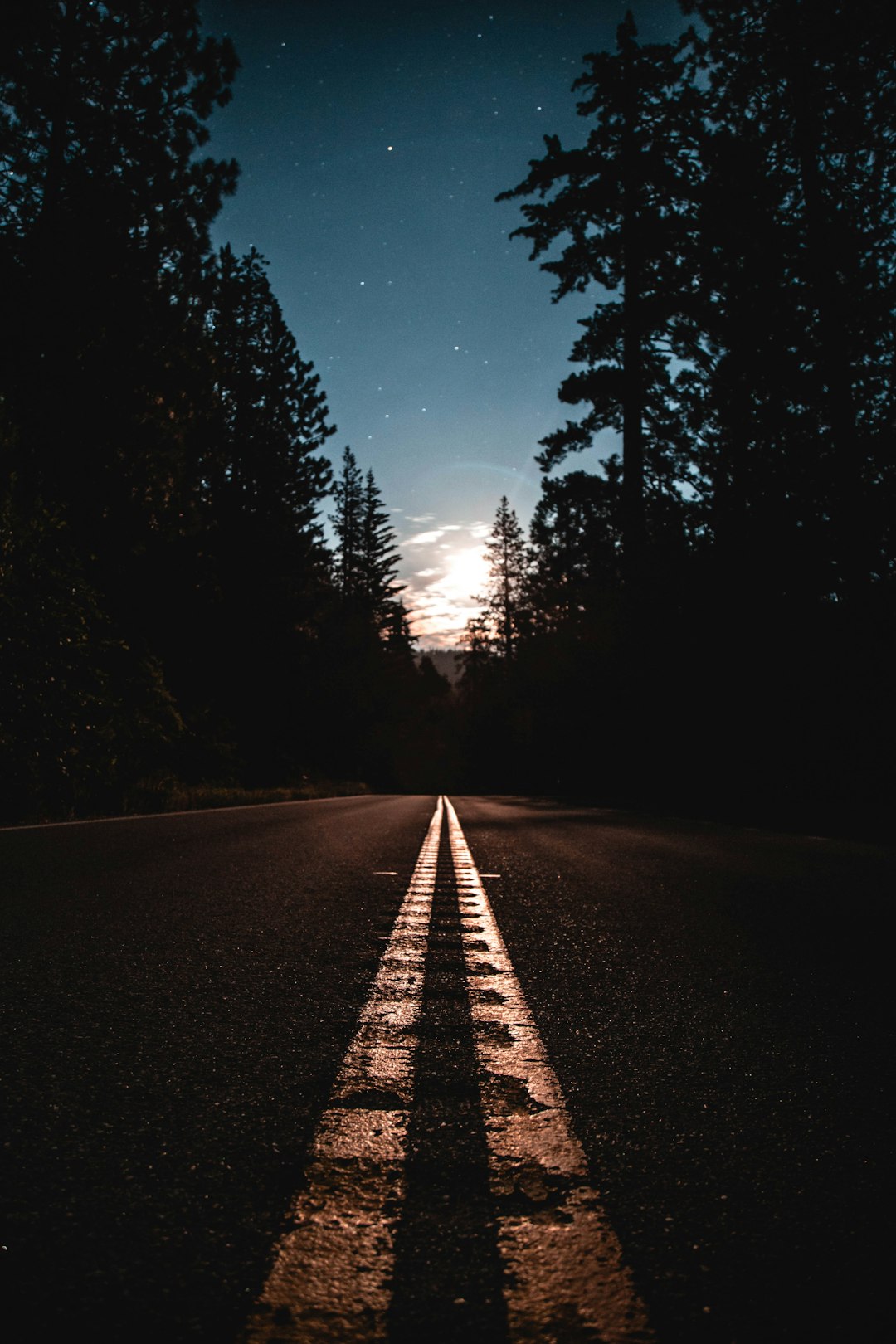 We were shooting Milky Way around midnight on our first night in Yosemite. We came across this straight away where the full moon happened to be perfectly framed in the dead middle of the road. I told my buddy to stop the car so we could get out and take shots of this once in a lifetime moment.