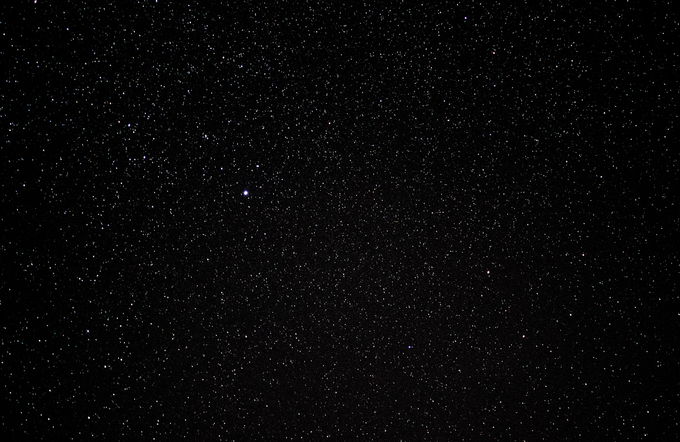 Milky Way and stars above a rugged mountain horizon