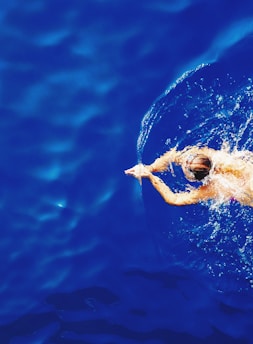 close-up photography of woman swimming on calm water