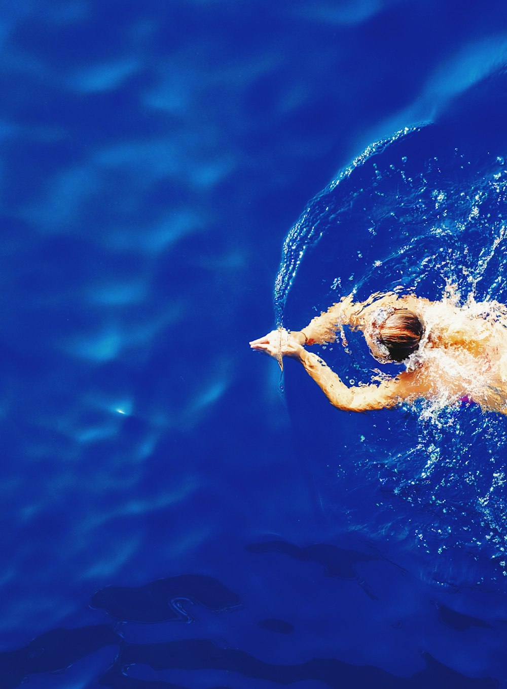 Photographie en gros plan d’une femme nageant sur de l’eau calme