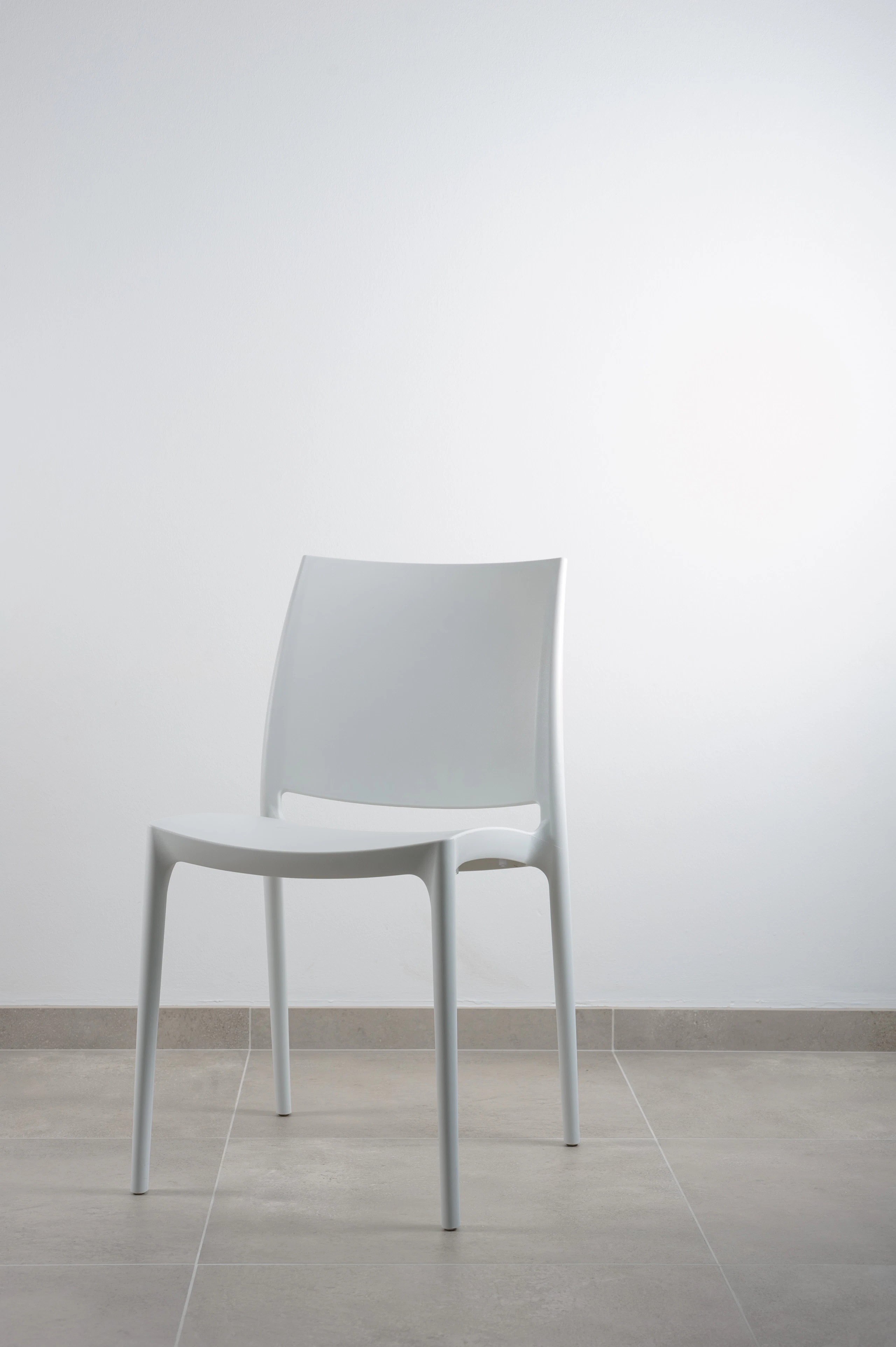 White stacking chair in an empty room