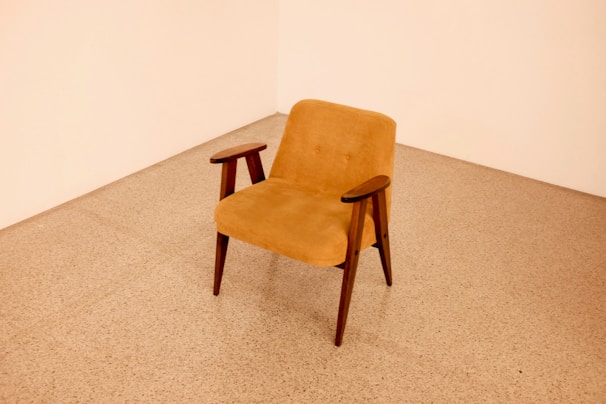 brown wooden framed beige padded chair