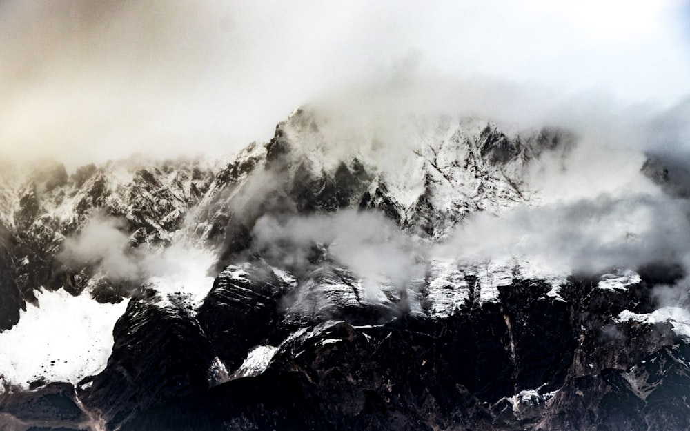 mountain ranges covered in snow and white fog