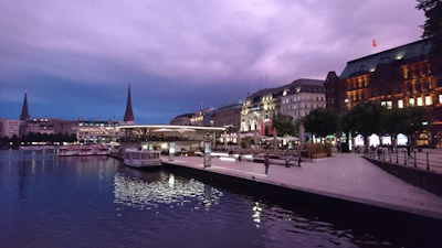 Evening view of a waterfront pavilion with warm lighting.