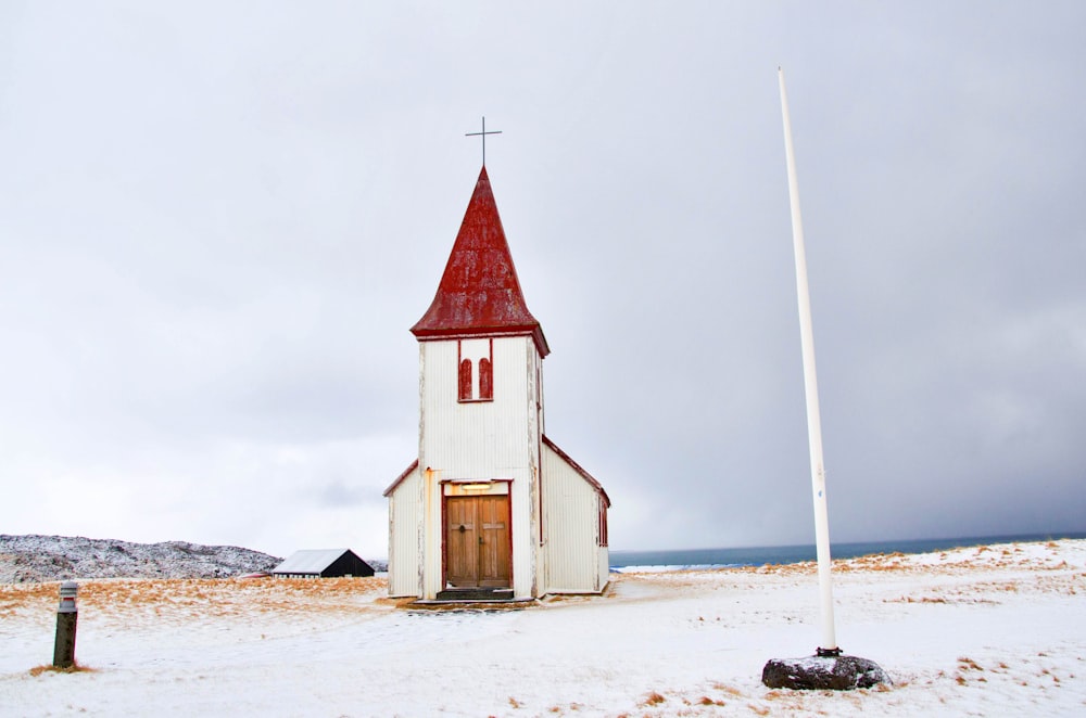 Poste blanco cerca de la capilla blanca y roja