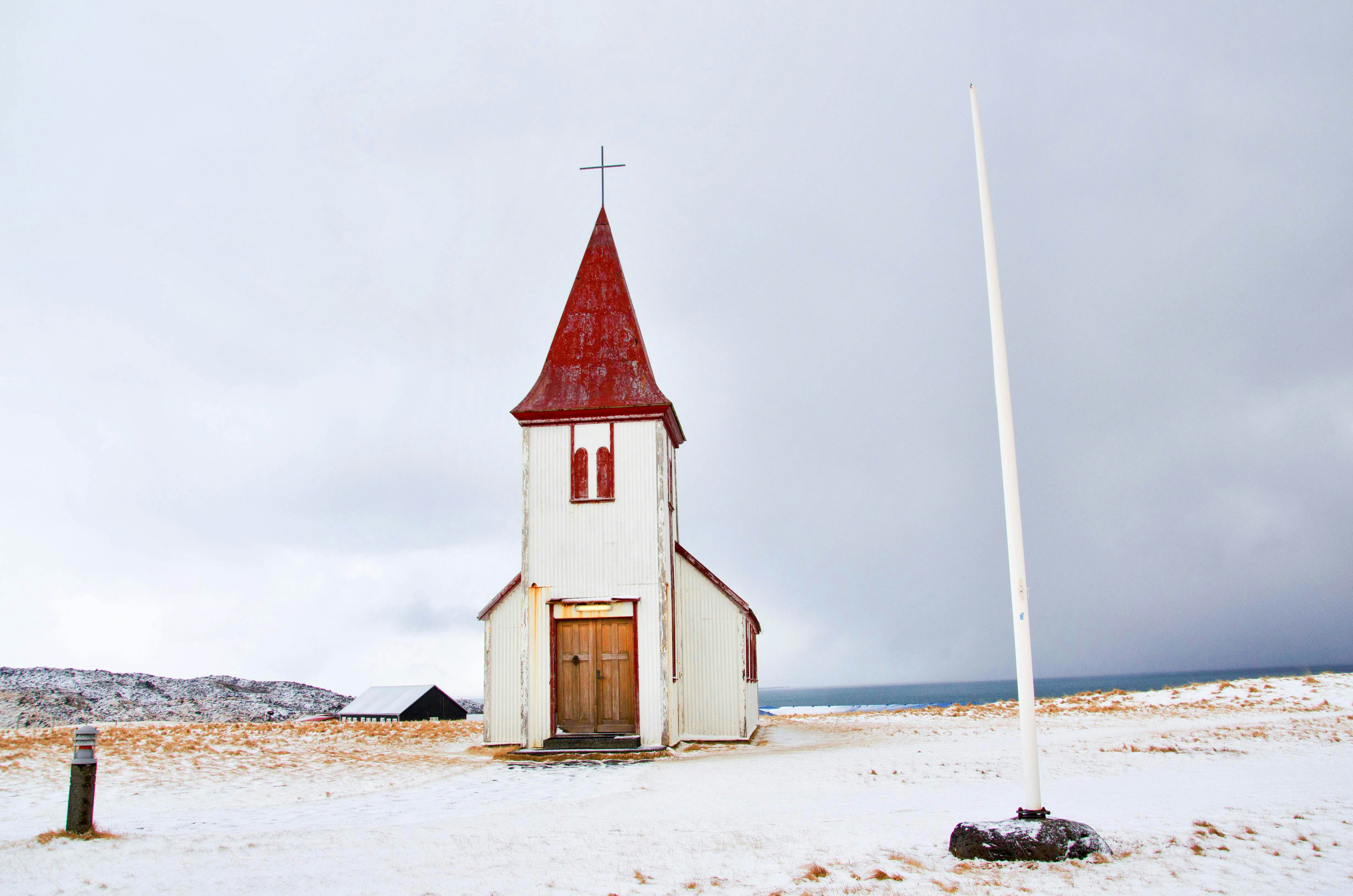 white pole near white and red chapel