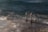Stainless steel handrails leading into the ocean, with waves gently crashing against a concrete platform. The scene is captured during twilight, adding a mysterious and serene ambiance.