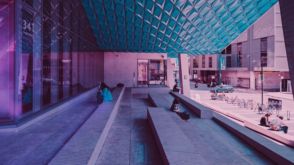 woman sitting on sidewalk near building