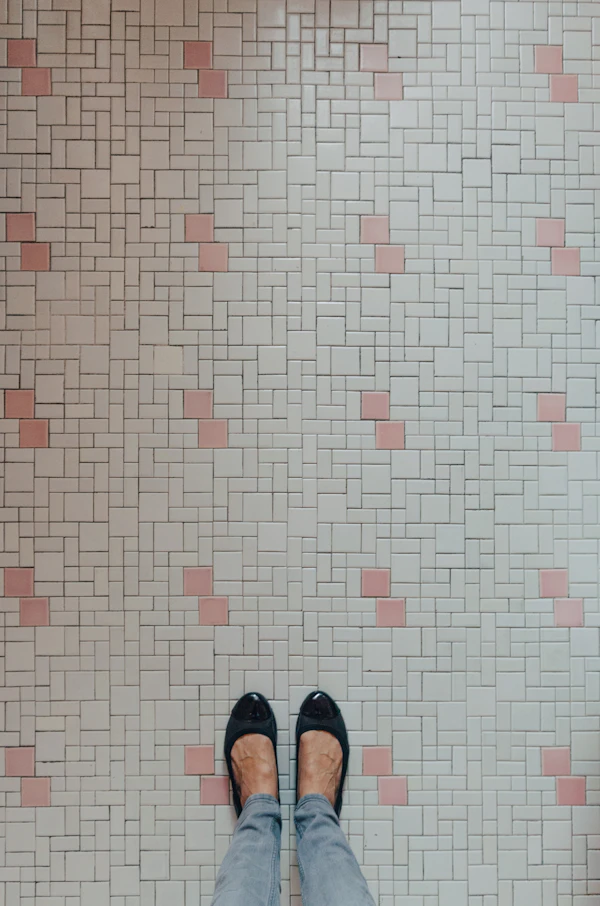 Tile and Grout Maintenance: a person standing in front of a tiled wall