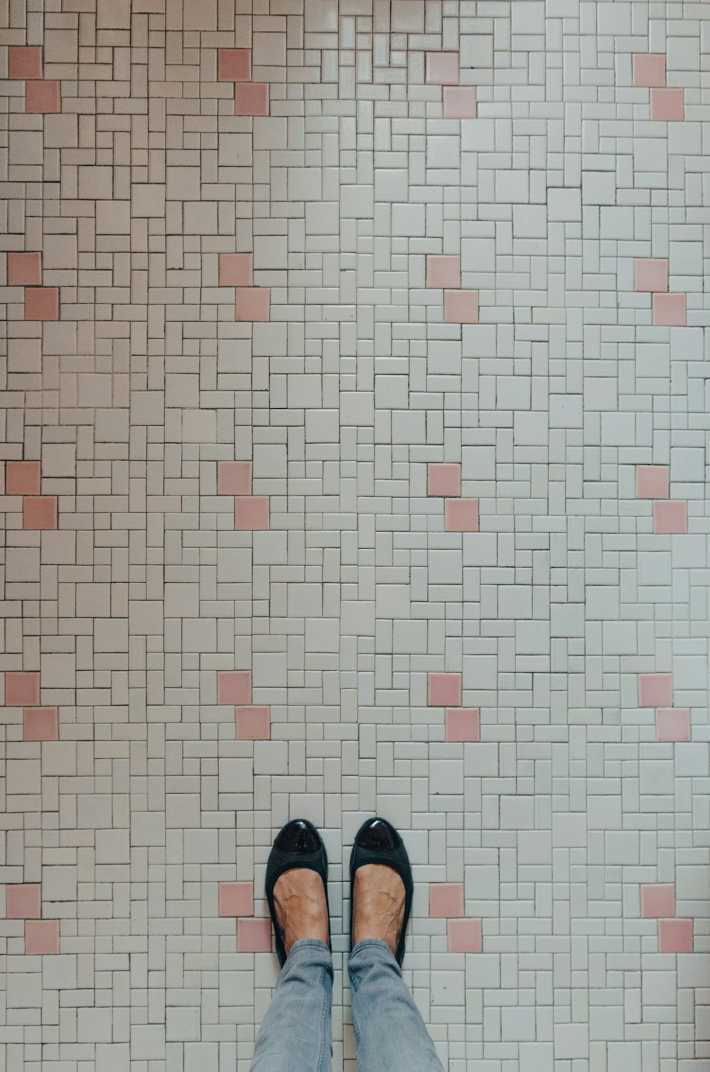a person standing in front of a tiled wall