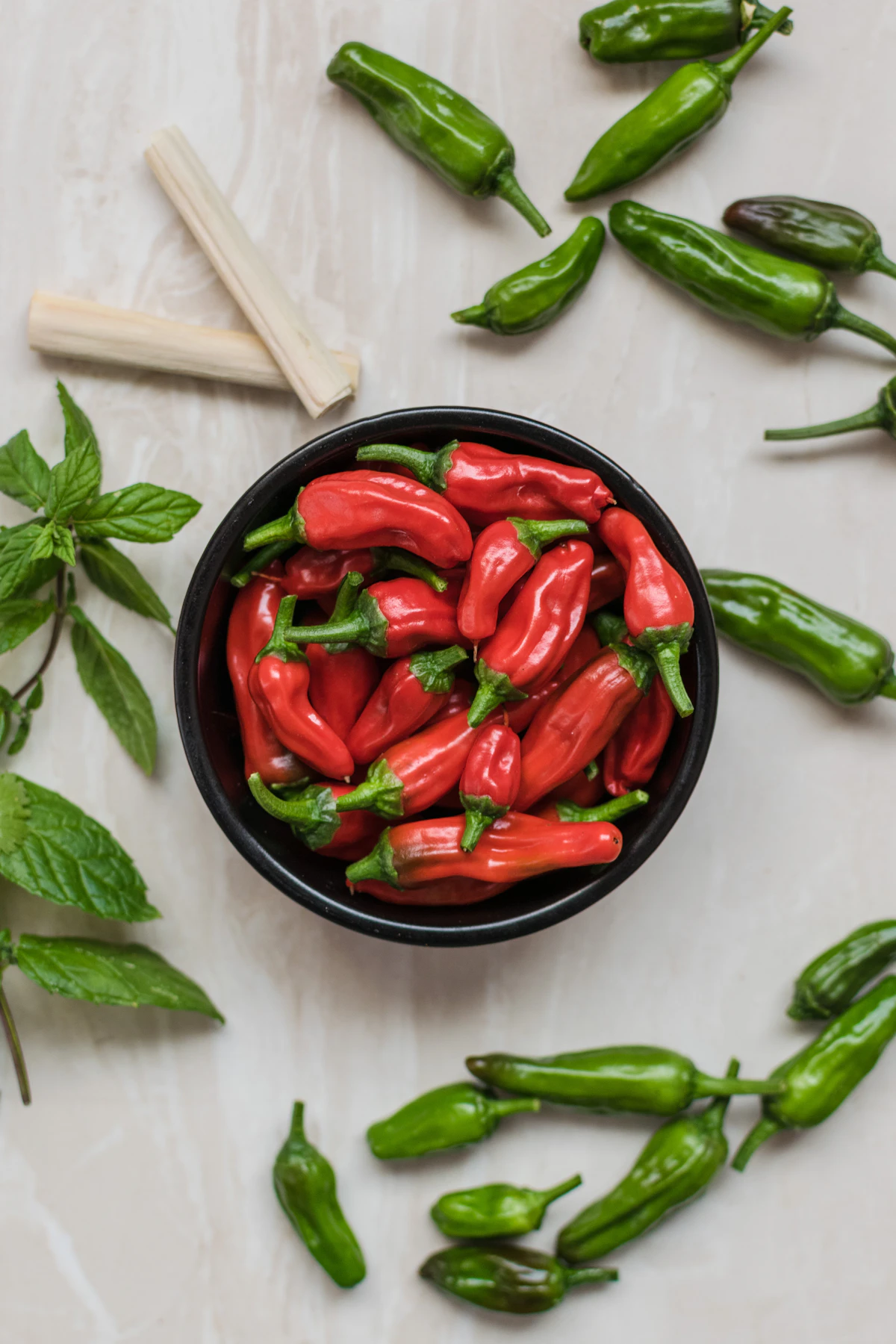 Close-up photography of red bell peppers surrounded by green bell peppers
