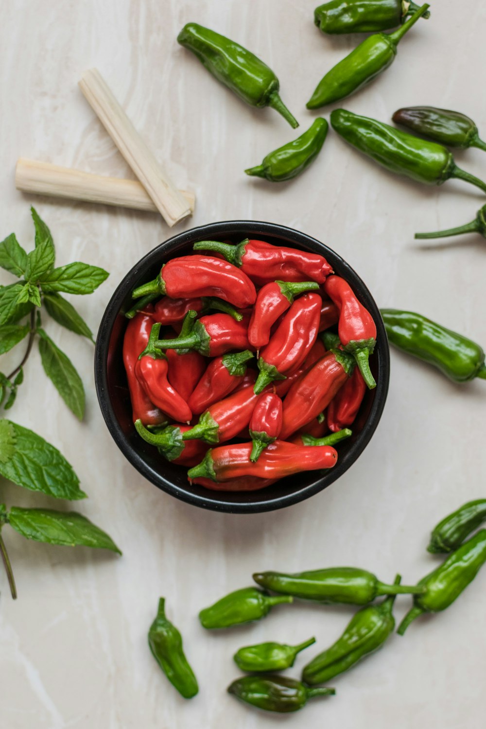 Fotografía de primer plano de pimientos rojos rodeados de pimientos verdes