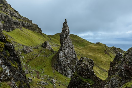 gray mountains surrounded by grass field in The Storr United Kingdom
