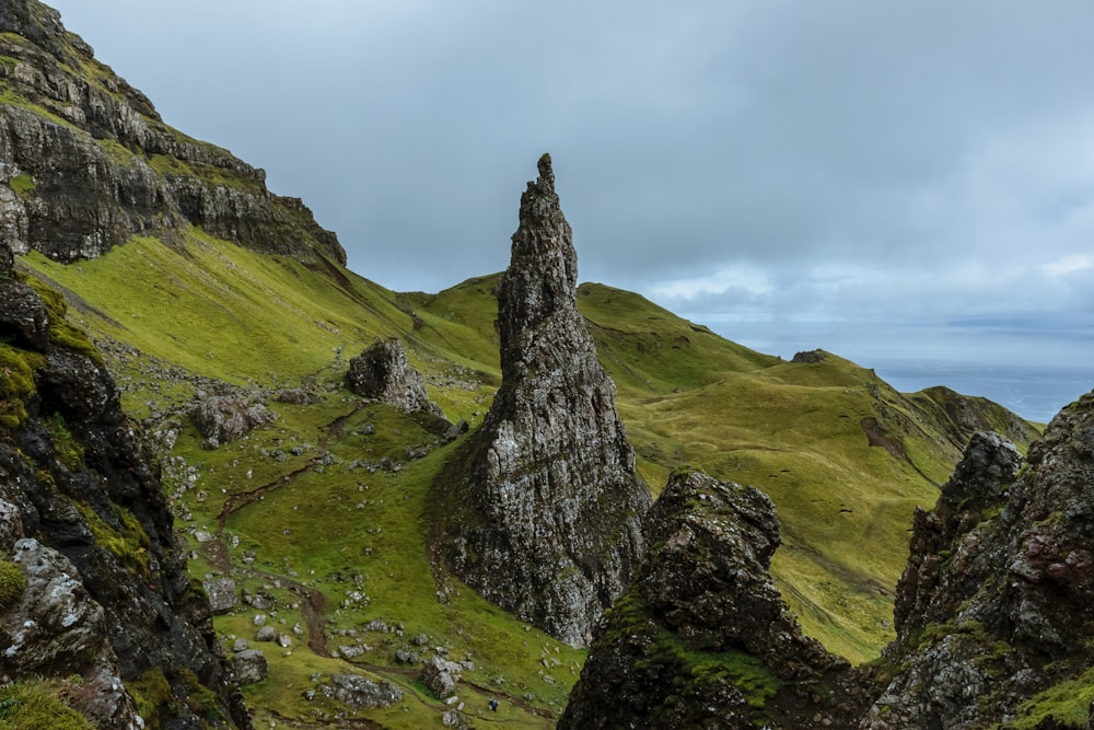 Montagnes grises entourées d’un champ d’herbe