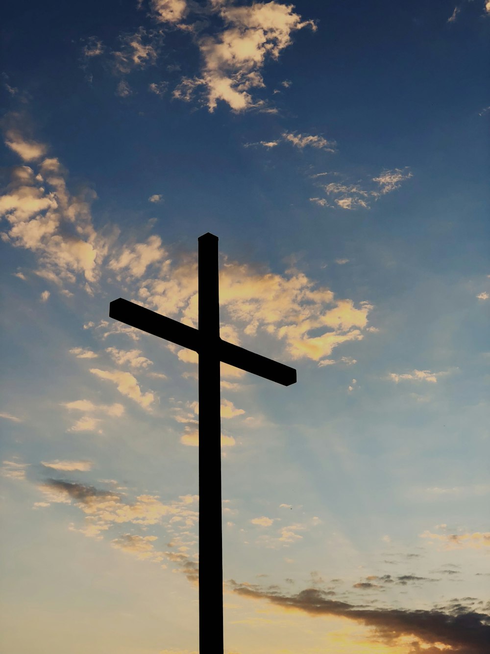 silhueta da cruz sob o céu azul