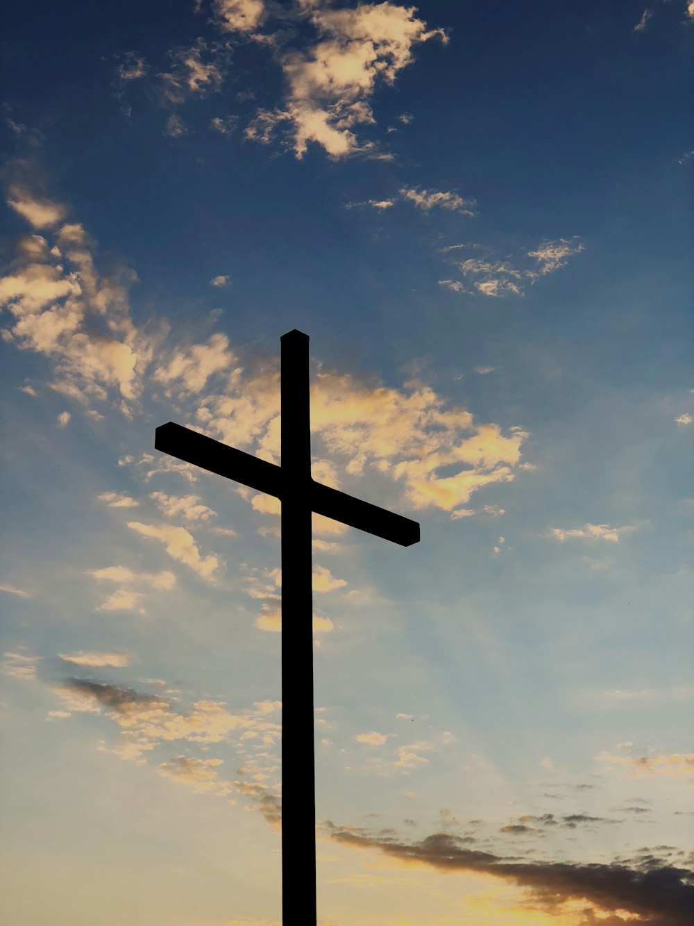 silhouette of cross under blue sky