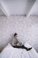 A traveler booking a flight on a laptop in a cozy home setting.