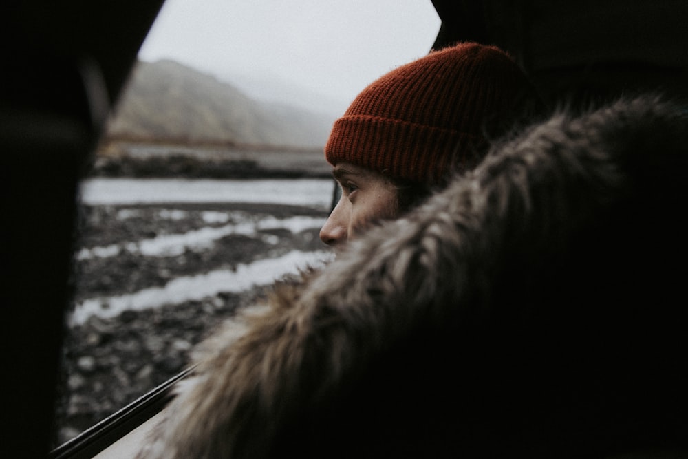 shallow focus photography of woman starring outside the window