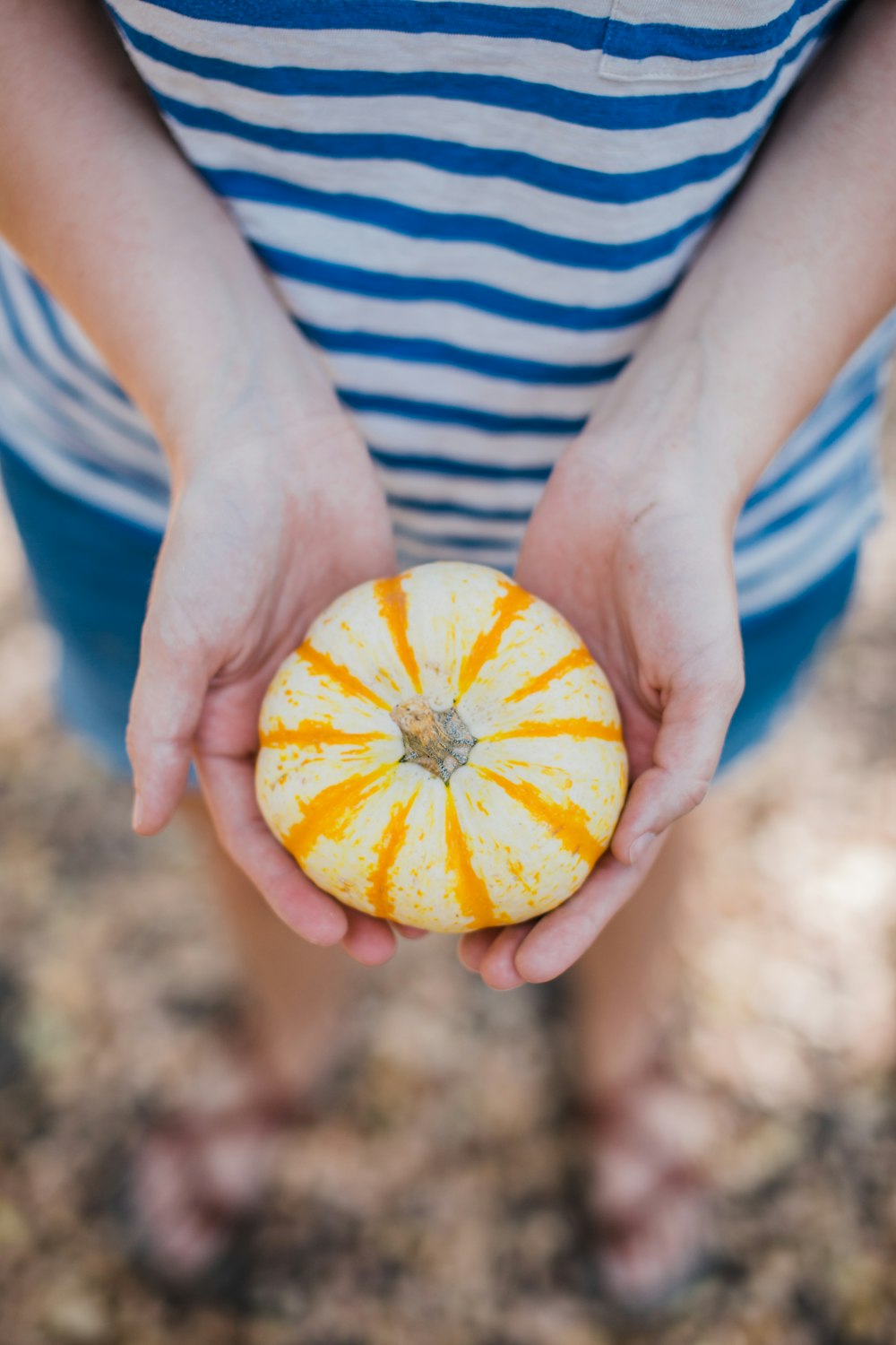 a person holding a pumpkin in their hands