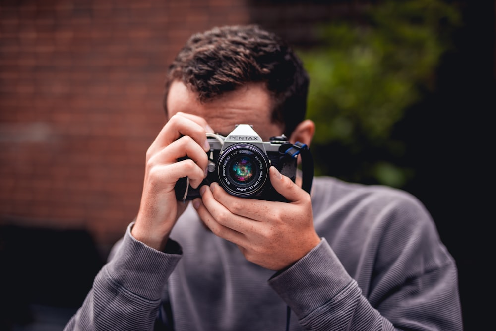 person taking photo using Pentax DSLR camera