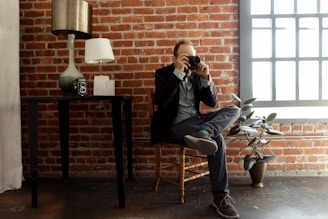 A user taking a photo of a vintage wooden chair to upload for selling.